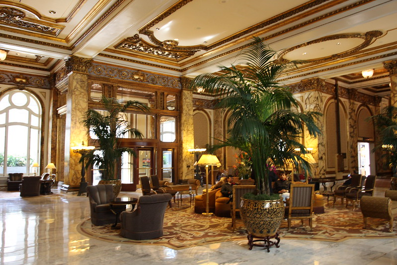 A large lobby of the Fairmont San francisco hotel with lots of furniture and plants
