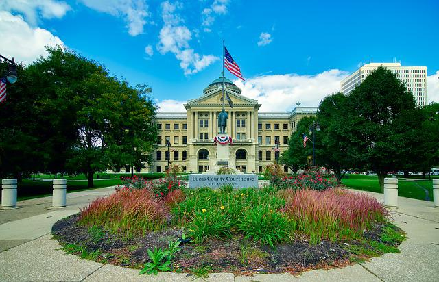 A large building with an american flag on top of it in toledo