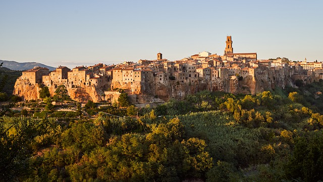 An aerial view of a small town in Tuscany surrounded by trees and mountains.