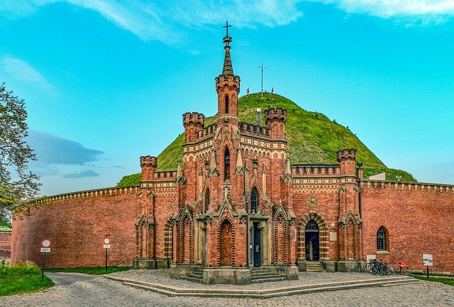 A large brick building with a tower on top of a hill in Krakow