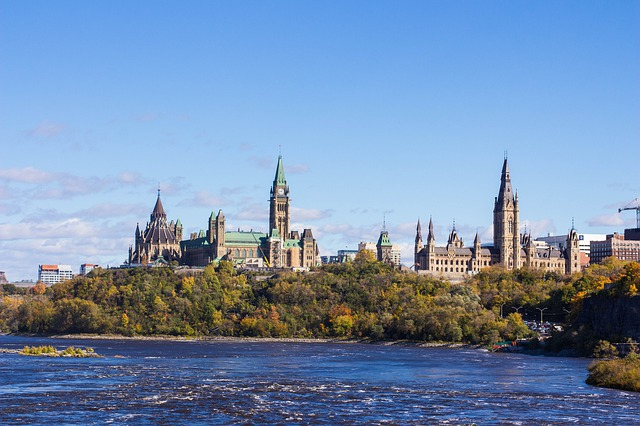 The Ottawa skyline with a river in the foreground and a large building in the background.