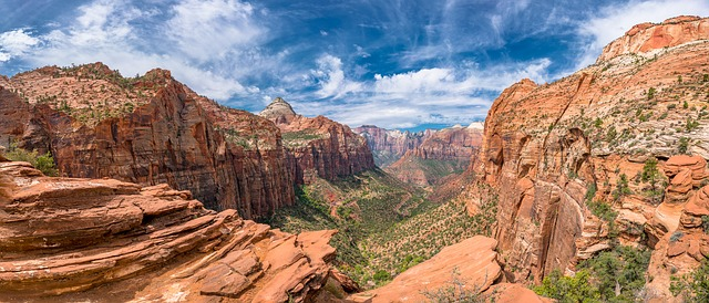 A panoramic view of a canyon in Utah with mountains in the background.