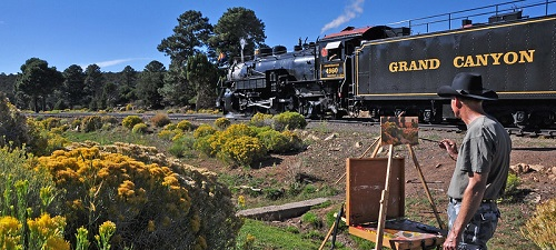 A man is painting a train on the grand canyon railroad