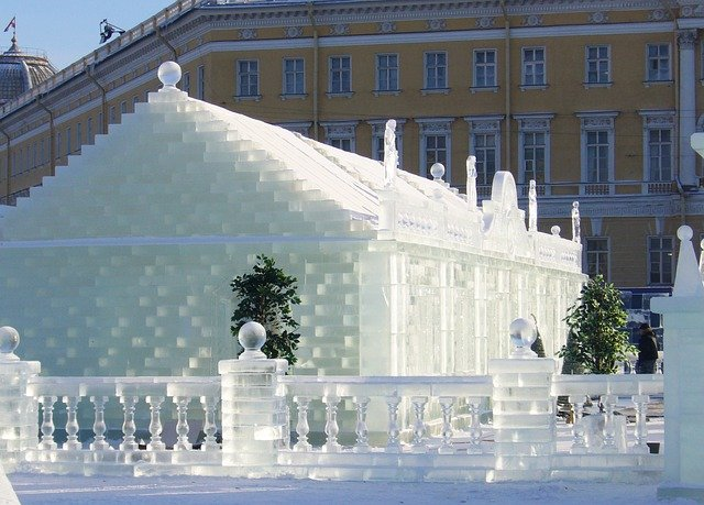 A building made out of ice with a yellow building in the background