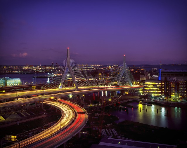An aerial view of a bridge over a body of water in Boston at night.