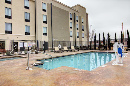 A large swimming pool in front of the comfort suites carlsbad hotel