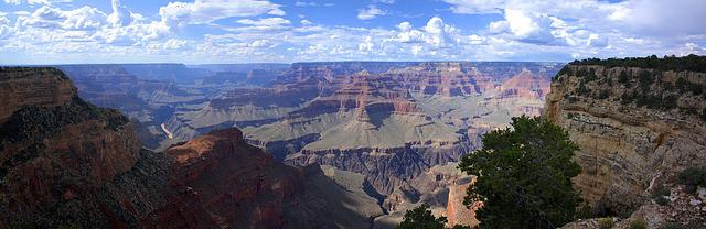 A view of the grand canyon from a cliff on a sunny day.