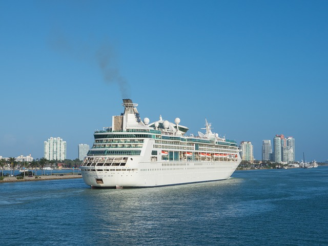 A large cruise ship off the coast of miami is floating on top of a body of water.