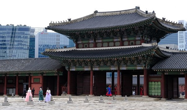 A group of people are standing in front of Gyeongbokgung Palace