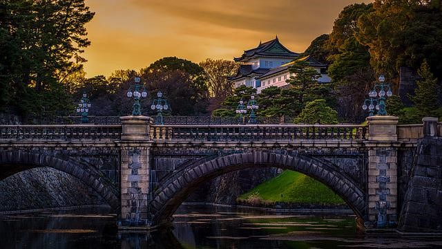 A bridge over a river in Tokyo with a castle in the background.
