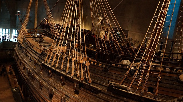 A large wooden ship with ropes and sails is sitting in Vasa Museum