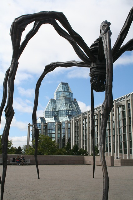 A statue of a spider with a building in the background
