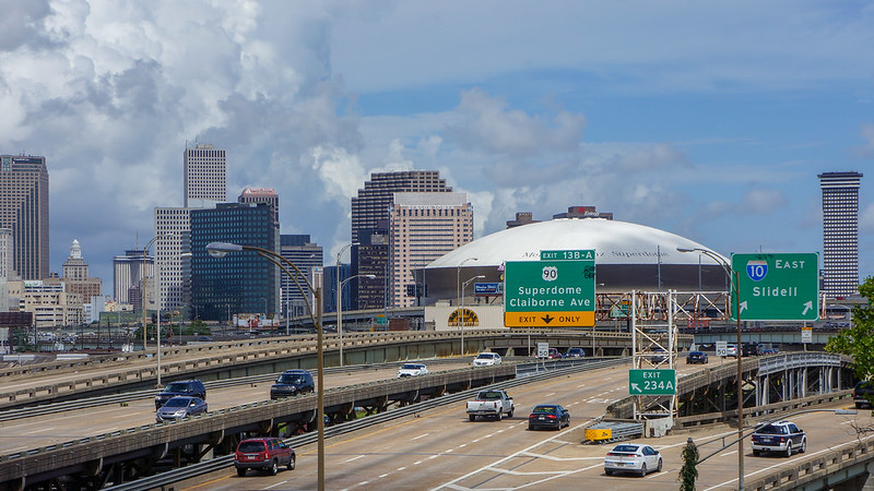 A highway going through new orleans with the superdome in the background.