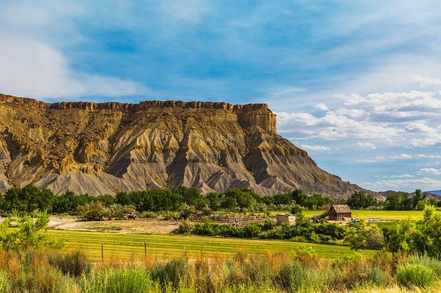 Capitol Reef NP with a mountain in the background and a house in the foreground.