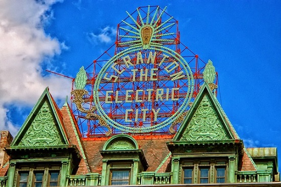 A building with a neon sign on top of it that says Scranton the electric city.