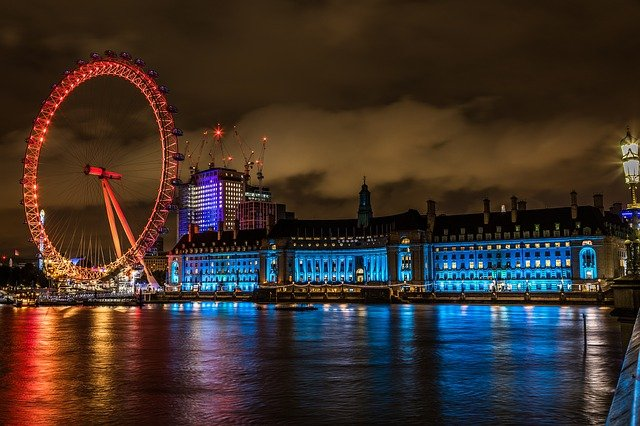 The London Eye ferris wheel is lit up at night in London.