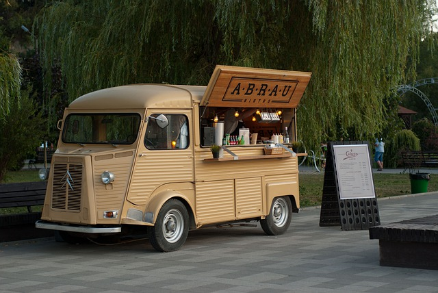 A food truck is parked in a park next to a tree in miami
