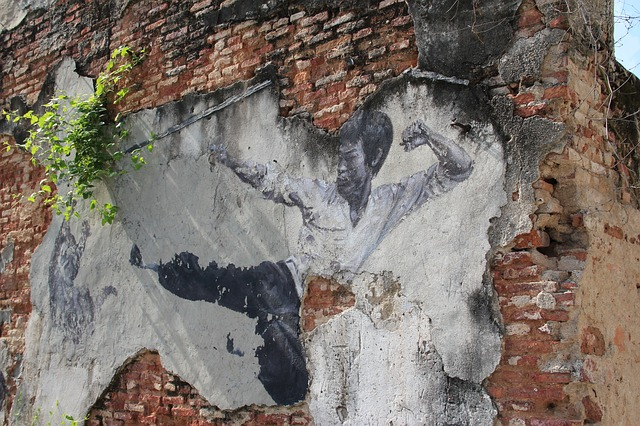 A brick wall with a painting of a man on it in penang.