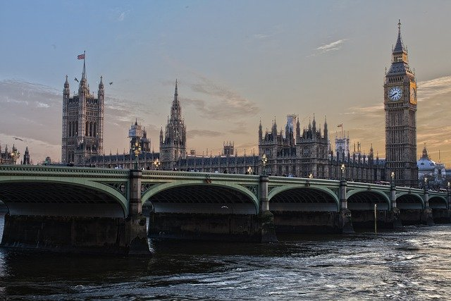 A bridge over a river in london with big ben in the background.