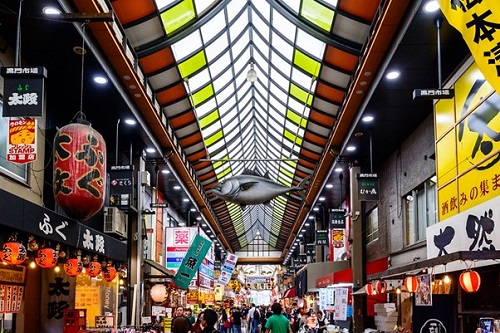 A large fish is hanging from the ceiling of Kuromon Market