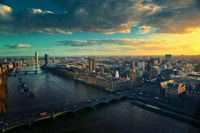 An aerial view of London with a river and bridges at sunset.