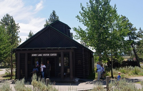 A group of people are standing in front of the john lane visitor center in grand teton np