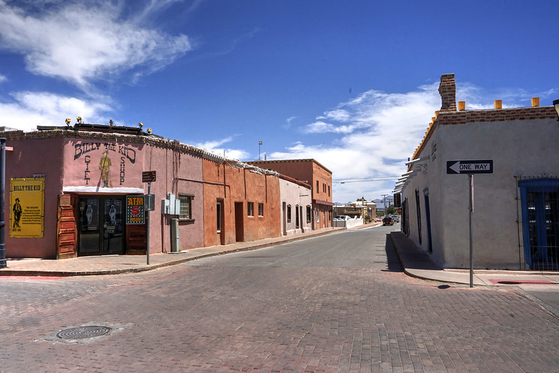 A corner of a street in Las Cruces with a sign that says one way