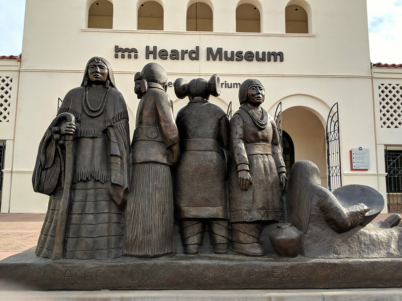 A statue of native americans in front of the heard museum