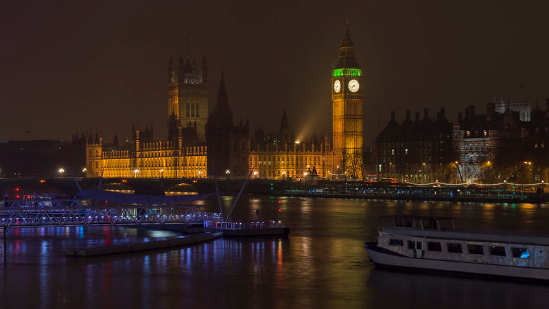 The big ben clock tower is lit up at night in london.