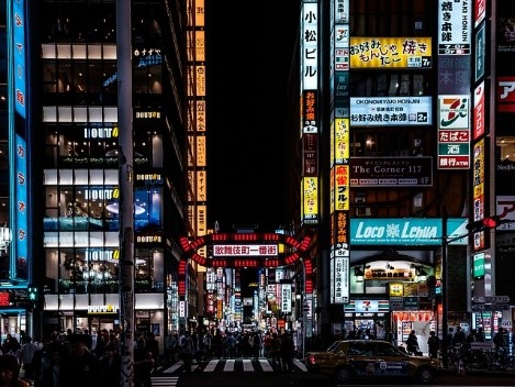 A busy Tokyo street at night with many neon signs