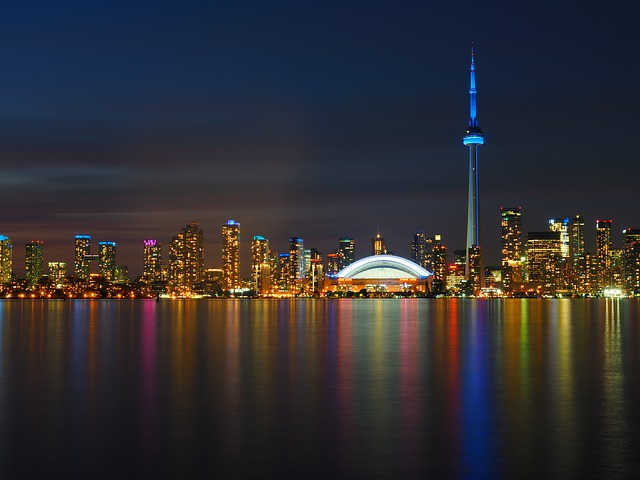The skyline of Toronto is reflected in the water at night.