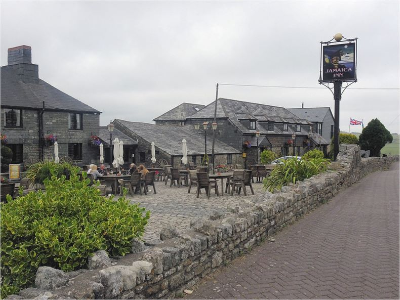 A stone wall surrounds the Jamaica Inn with tables and chairs outside