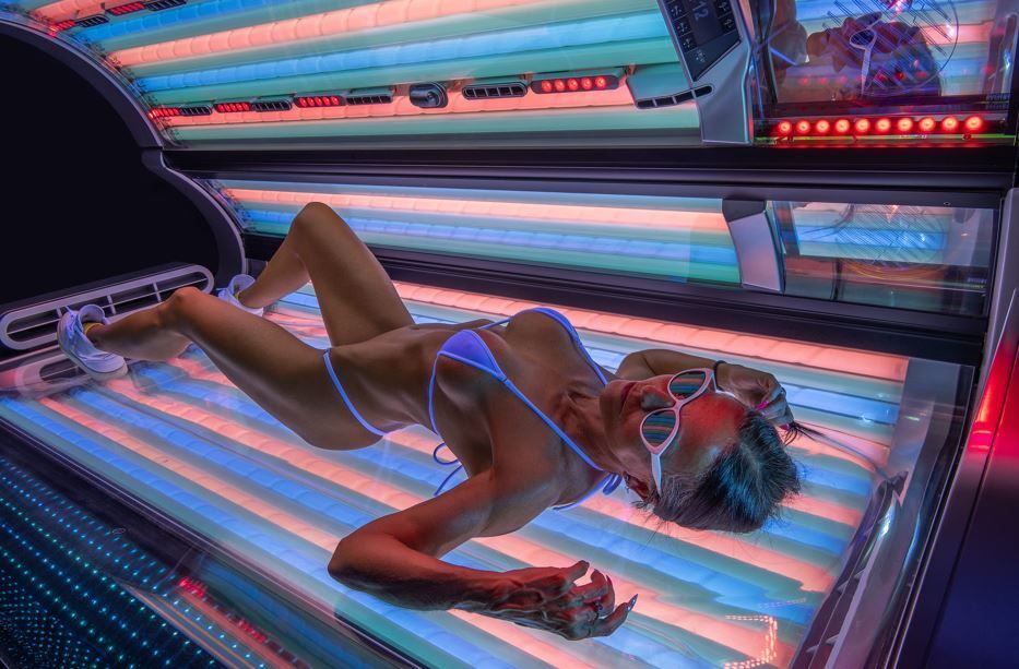 eine sportliche frau im bikini geniesst solarium