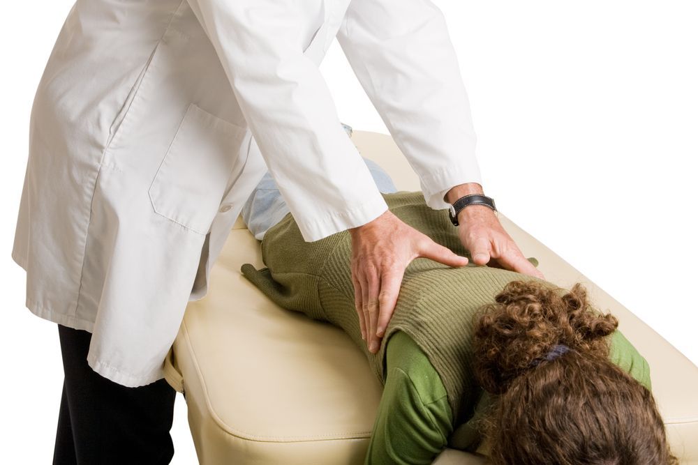 A Woman is Laying on a Table Getting a Massage From a Doctor — Back Care Gold Coast In Nerang, QLD