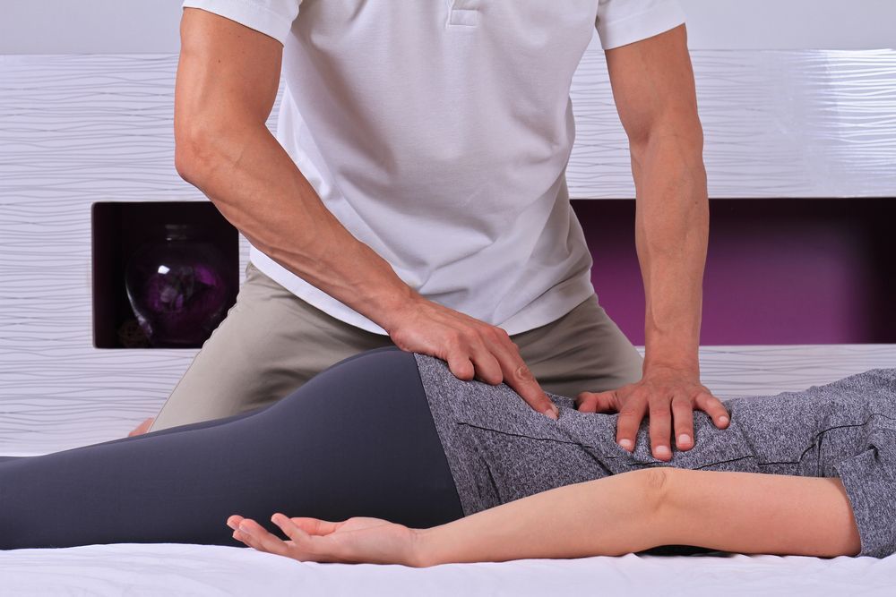 A Man is Giving a Woman a Massage on a Bed — Back Care Gold Coast In Nerang, QLD