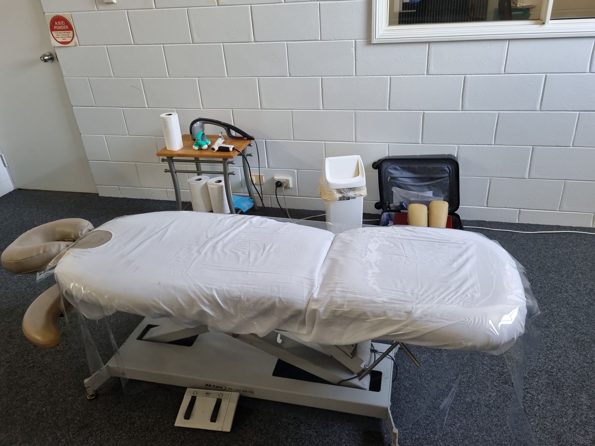 Examination Table in A Clinic Room with A Rolling Cart — Back Care Gold Coast In Nerang, QLD