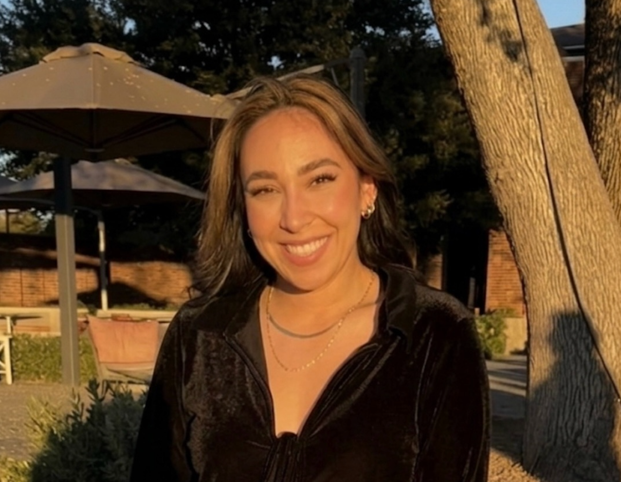 Photo of woman standing next to tree outside