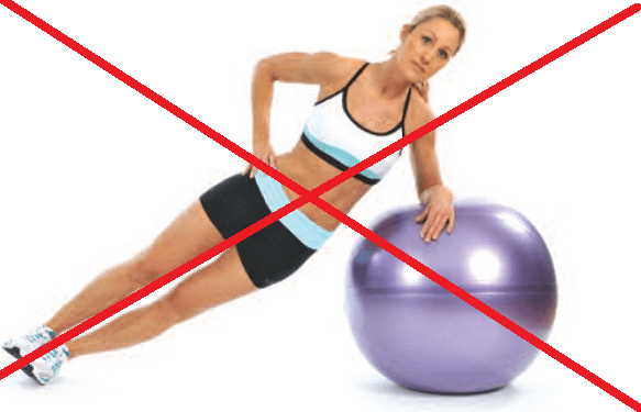 Uma mulher está fazendo uma prancha lateral ao lado de uma bola de pilates