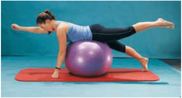 Uma mulher está fazendo prancha em uma bola de exercícios roxa.