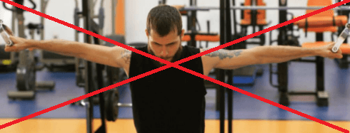 Um homem está em uma academia com os braços estendidos.