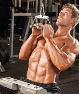 Um homem sem camisa está fazendo flexões em uma máquina em uma academia