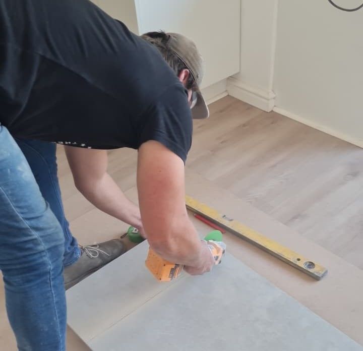 Tradesman repairing cracked floor tiles in a South African home
