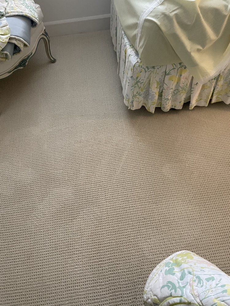 A bedroom with a bed and a chair on the floor.
