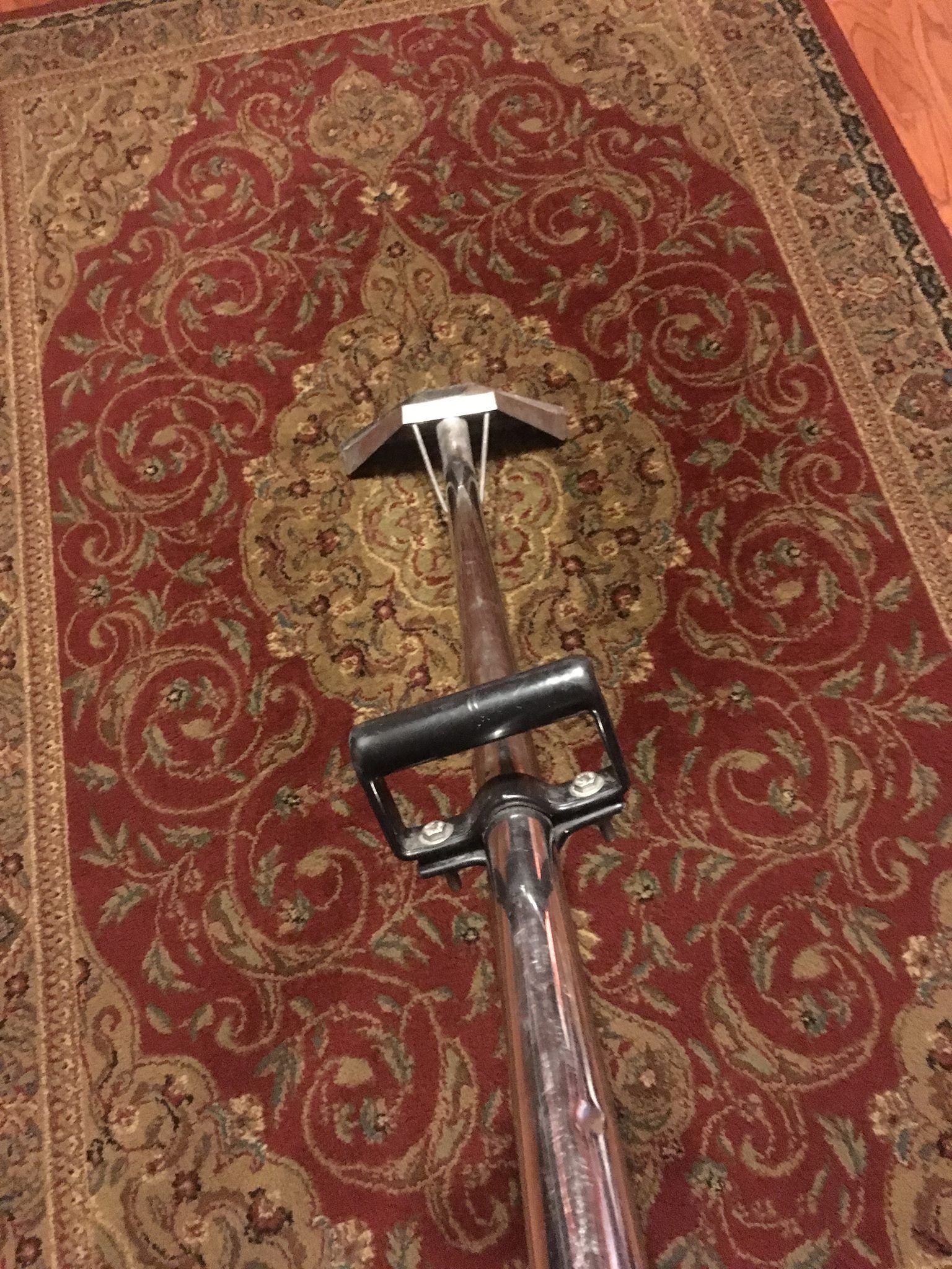 A vacuum cleaner is sitting on top of a rug.