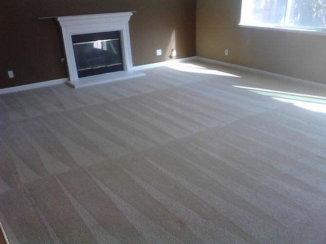 An empty living room with a fireplace and a window