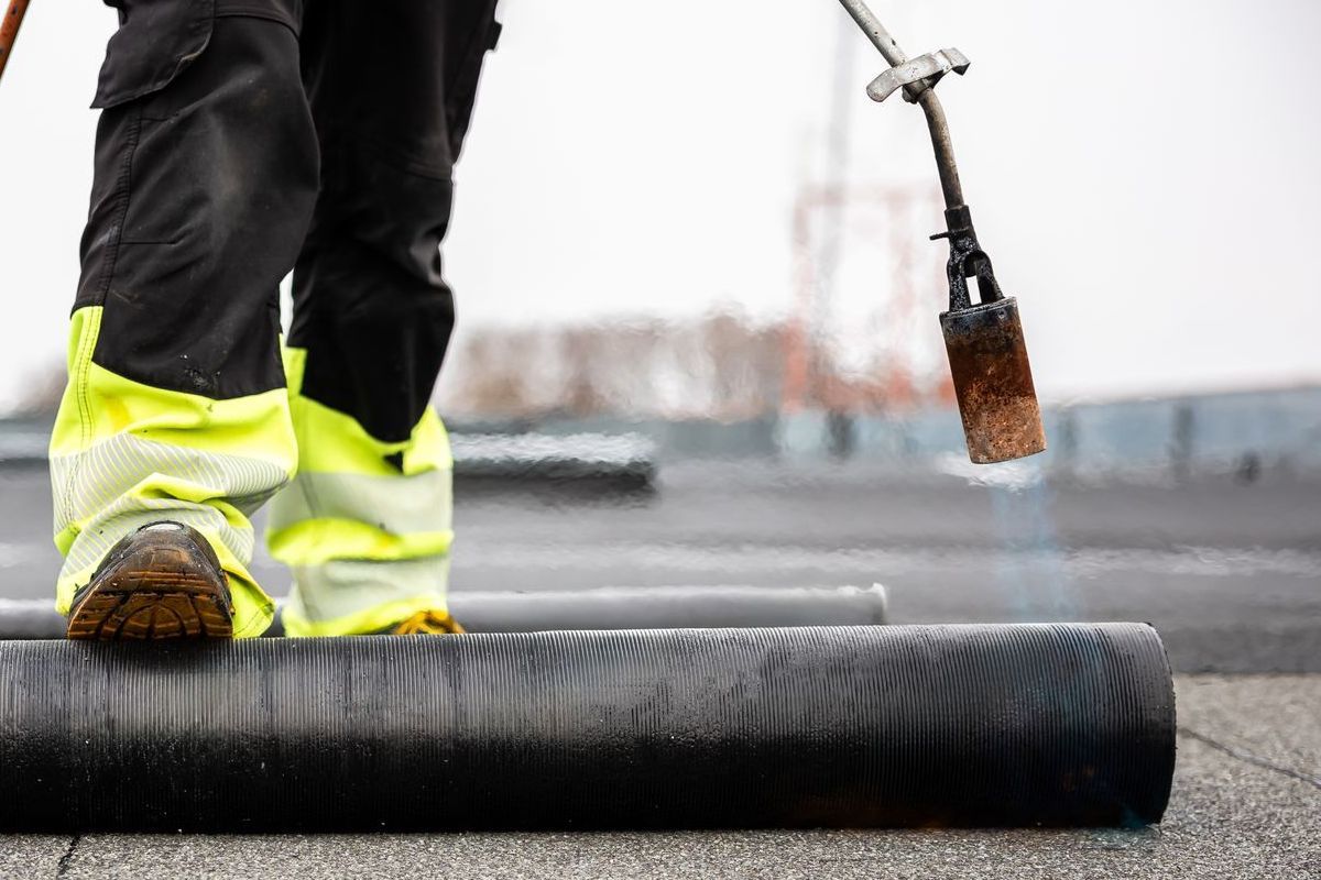 A person is standing on a roof with a torch.