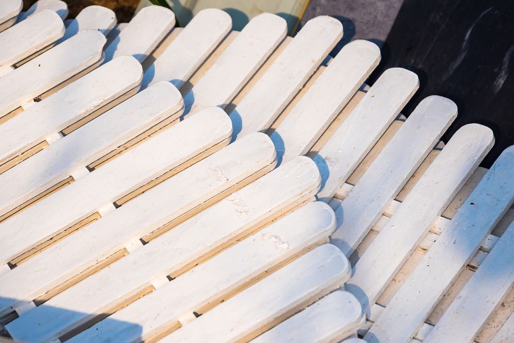 Close-up of white wooden popsicle sticks arranged in a pattern, casting shadows.