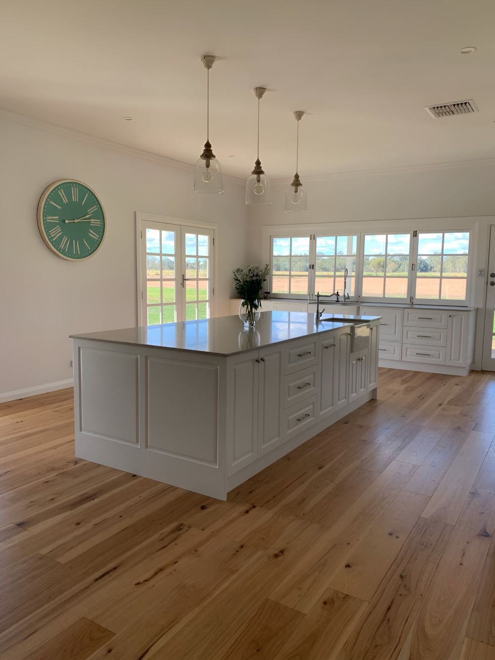 A Kitchen With A Large Island And A Clock On The Wall — Gavin Cummings Kitchens in Dubbo, NSW