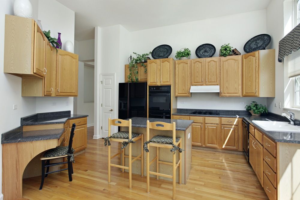 A Kitchen With Wooden Cabinets and a Black Refrigerator — Gavin Cummings Kitchens in Dubbo, NSW