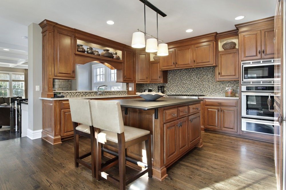 A Kitchen With Wooden Cabinets , Stainless Steel Appliances , and a Large Island — Gavin Cummings Kitchens in Dubbo, NSW